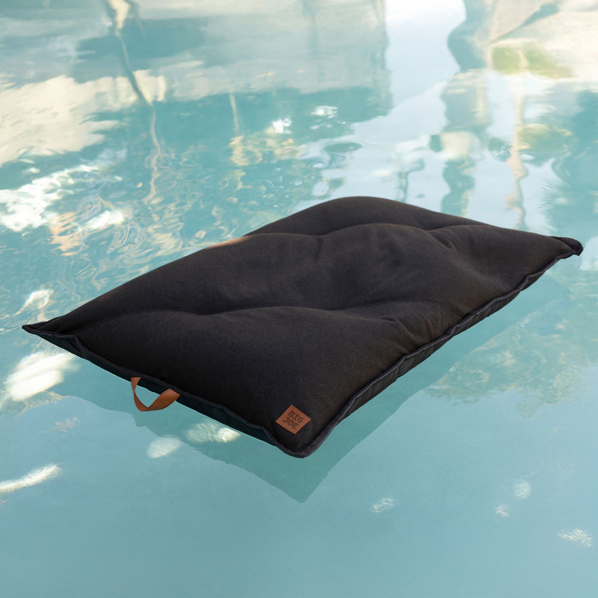 Black pet pool floatie floating on a pool