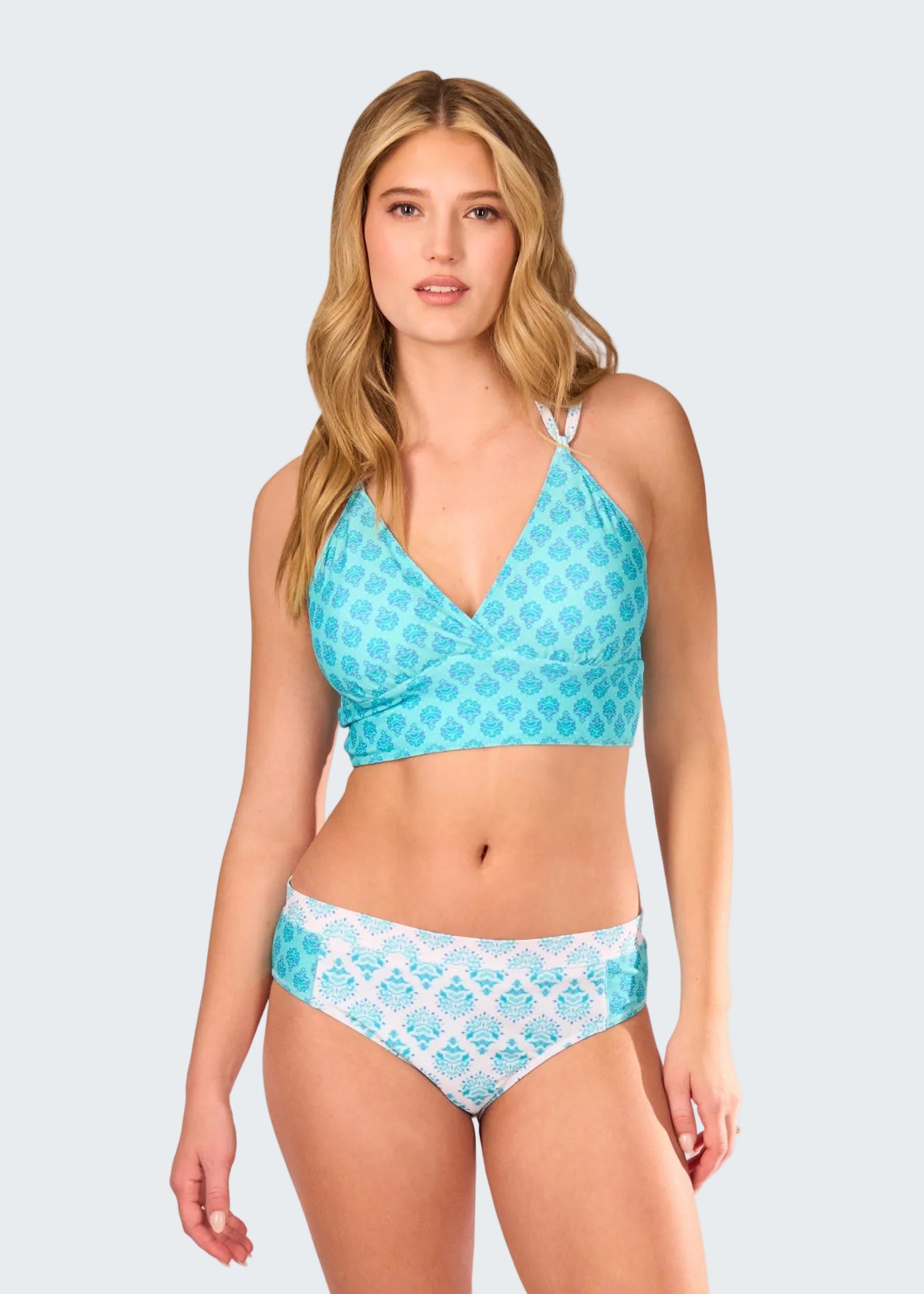 Woman wearing a blue and white patterned bikini set on a white background