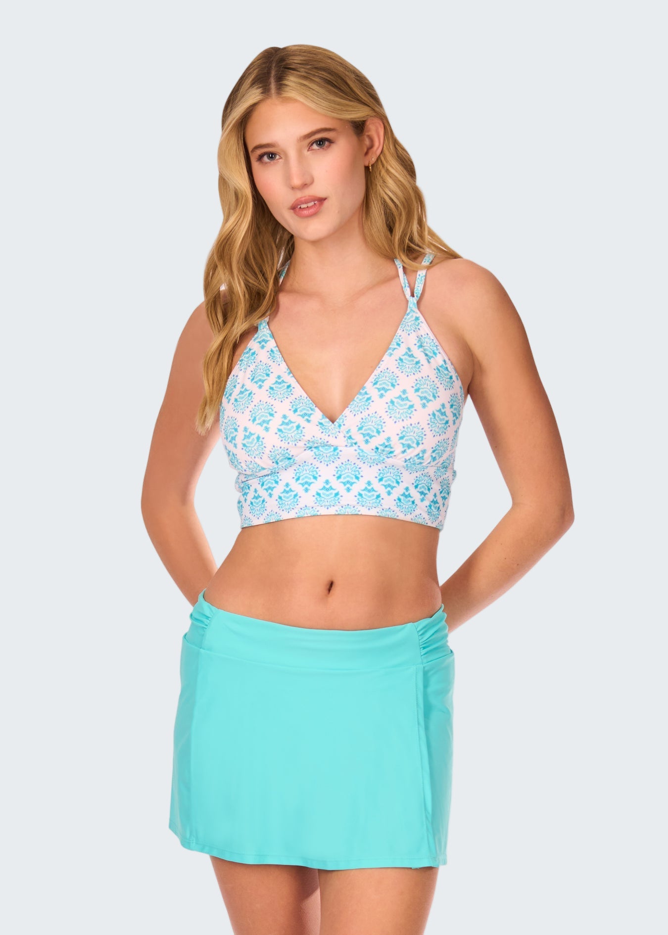 Woman wearing a light blue patterned top and matching skirt on a white background