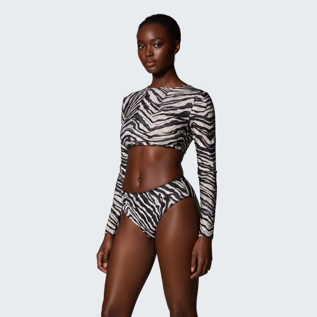 Model wearing a zebra print long-sleeve top and high-waisted bikini bottom on a neutral background