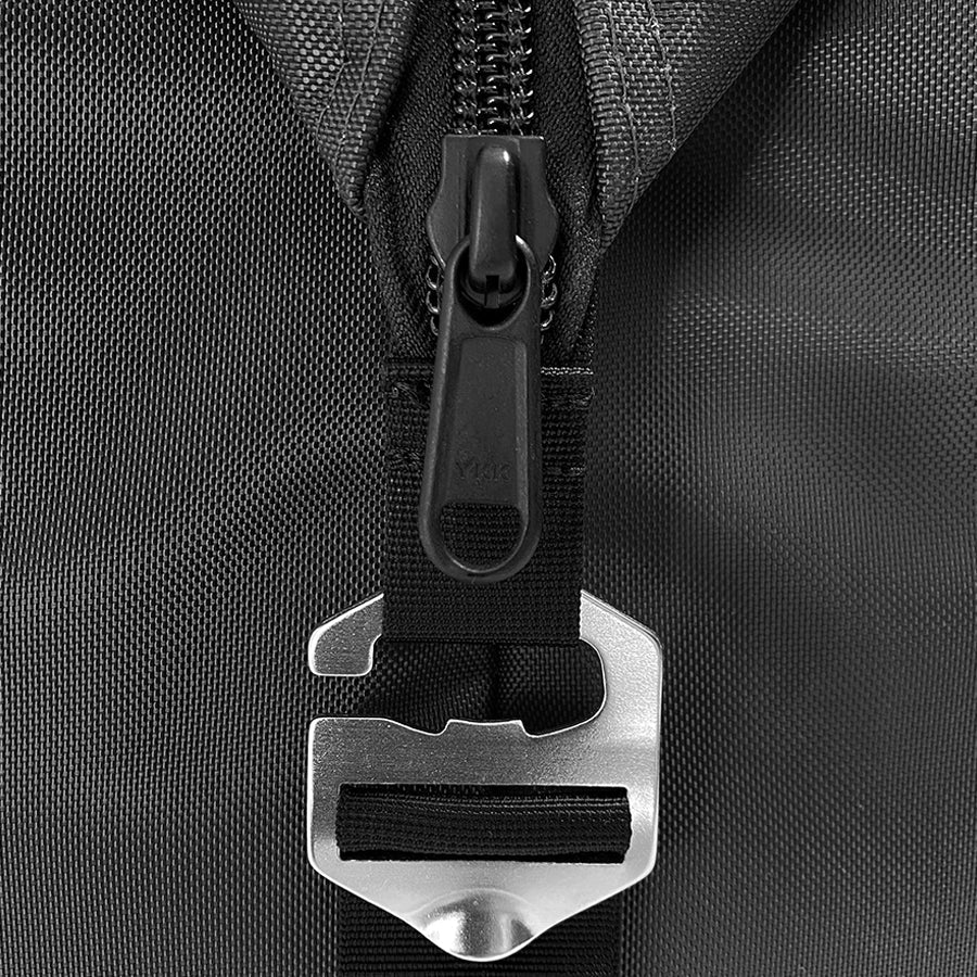 Close-up of a black backpack zipper with a metal buckle on a textured black background