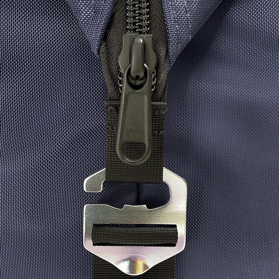 Close-up of a zipper on a dark blue backpack with a metal buckle detail.