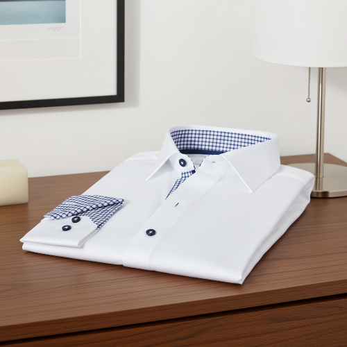 Folded white shirt with blue plaid interior on a wooden surface