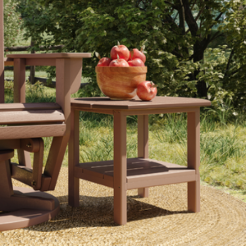 Wooden outdoor table with a bowl of apples on a grassy area