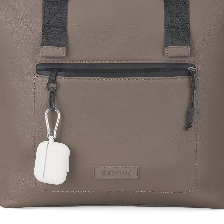 Brown bag with a white air pod case hanging from a strap on a white background