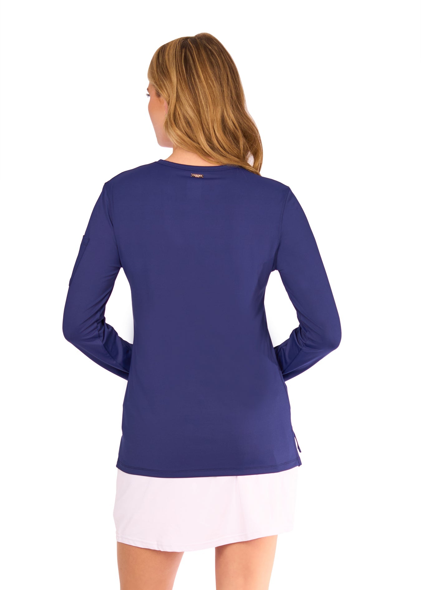 Woman wearing a blue long-sleeve top and white skirt on a white background