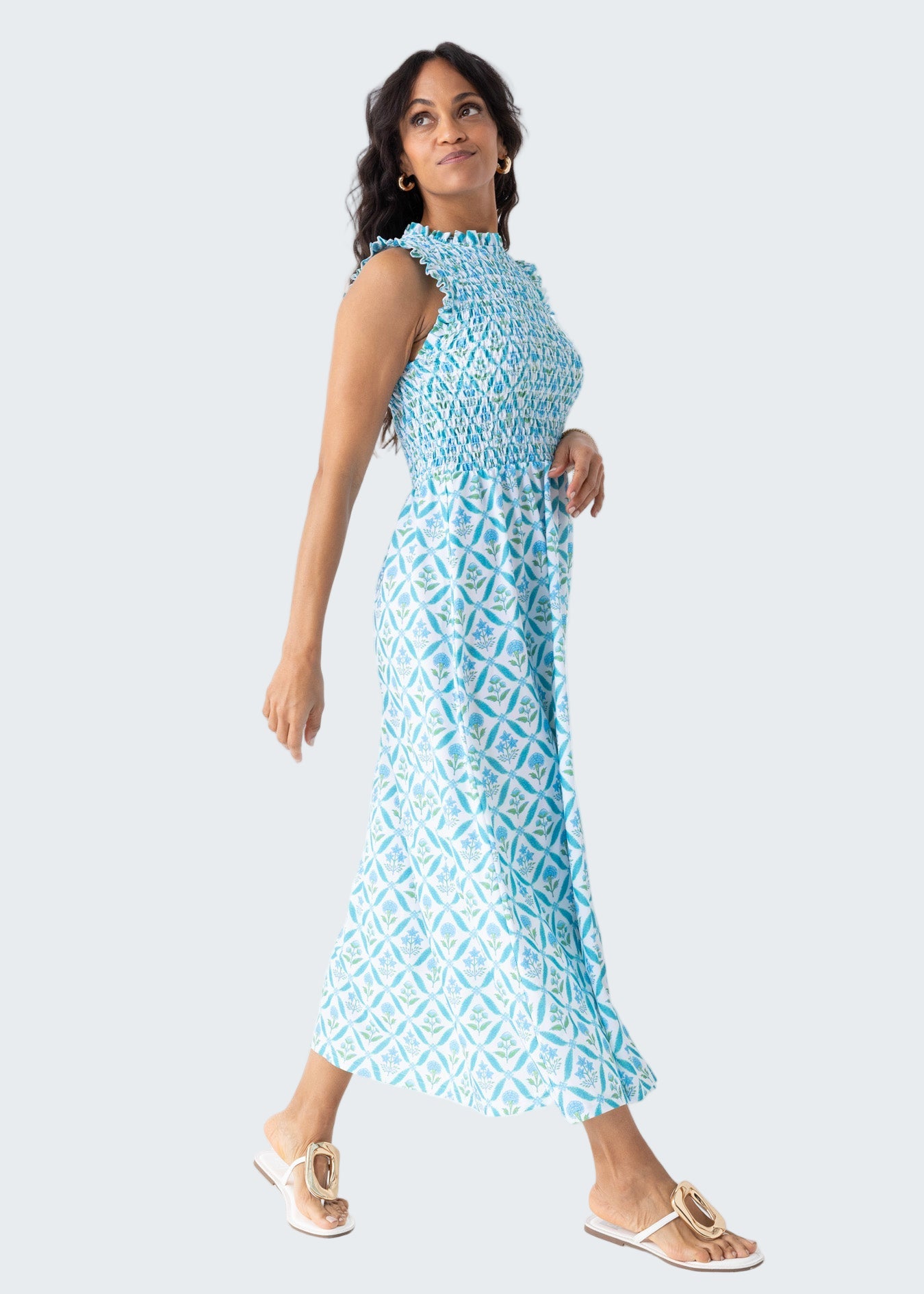 Woman wearing a blue patterned dress against a white background