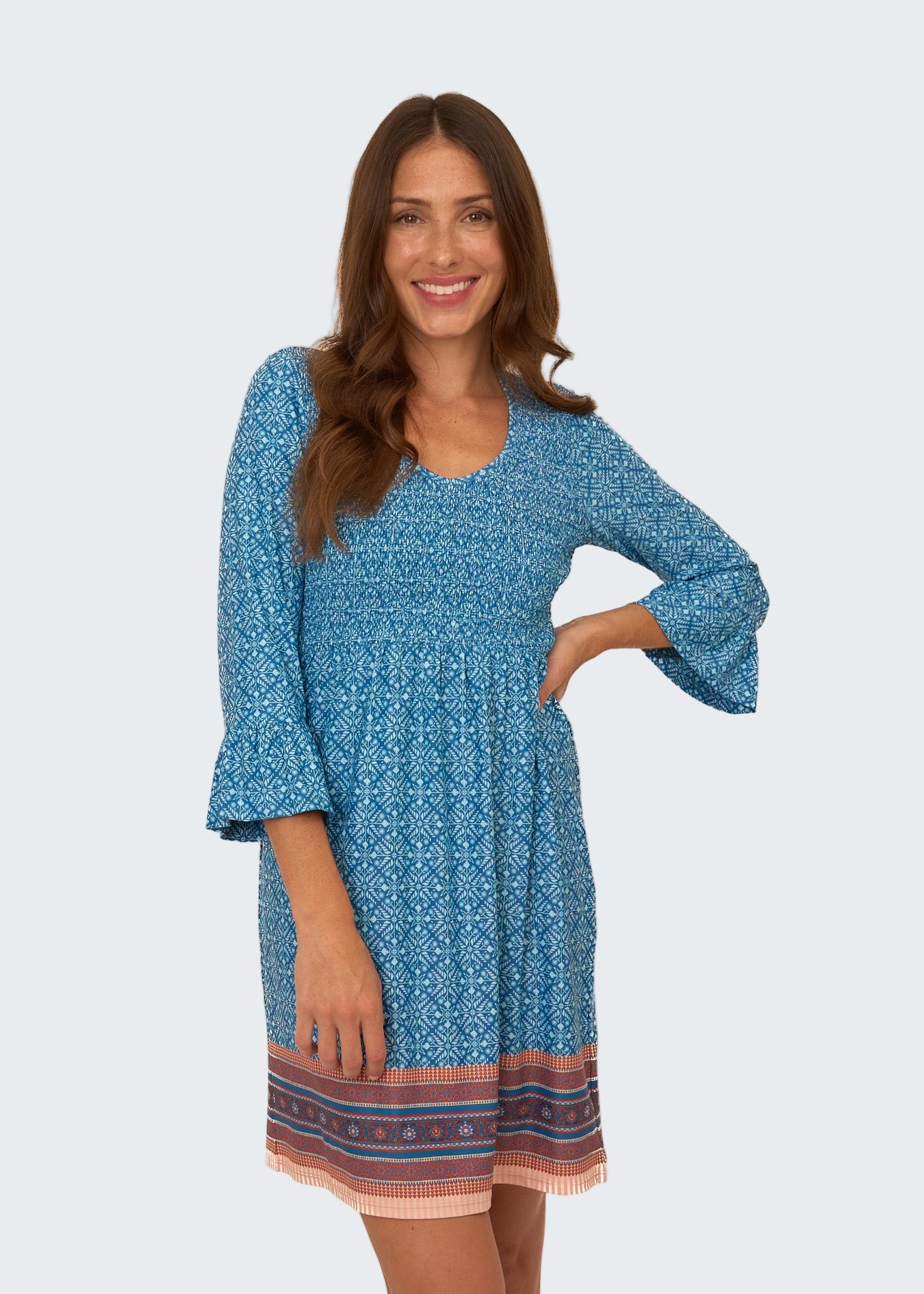 Woman wearing a blue patterned dress on a white background