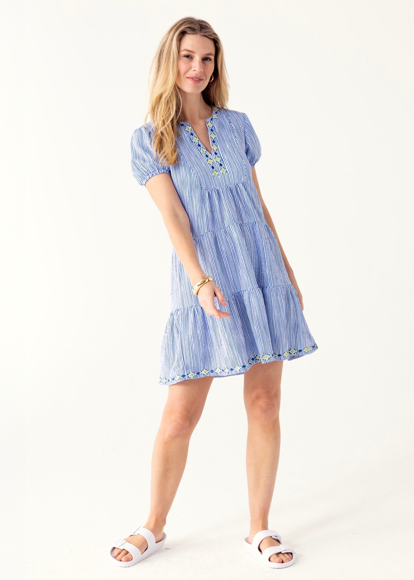 Woman wearing a blue striped dress on a white background