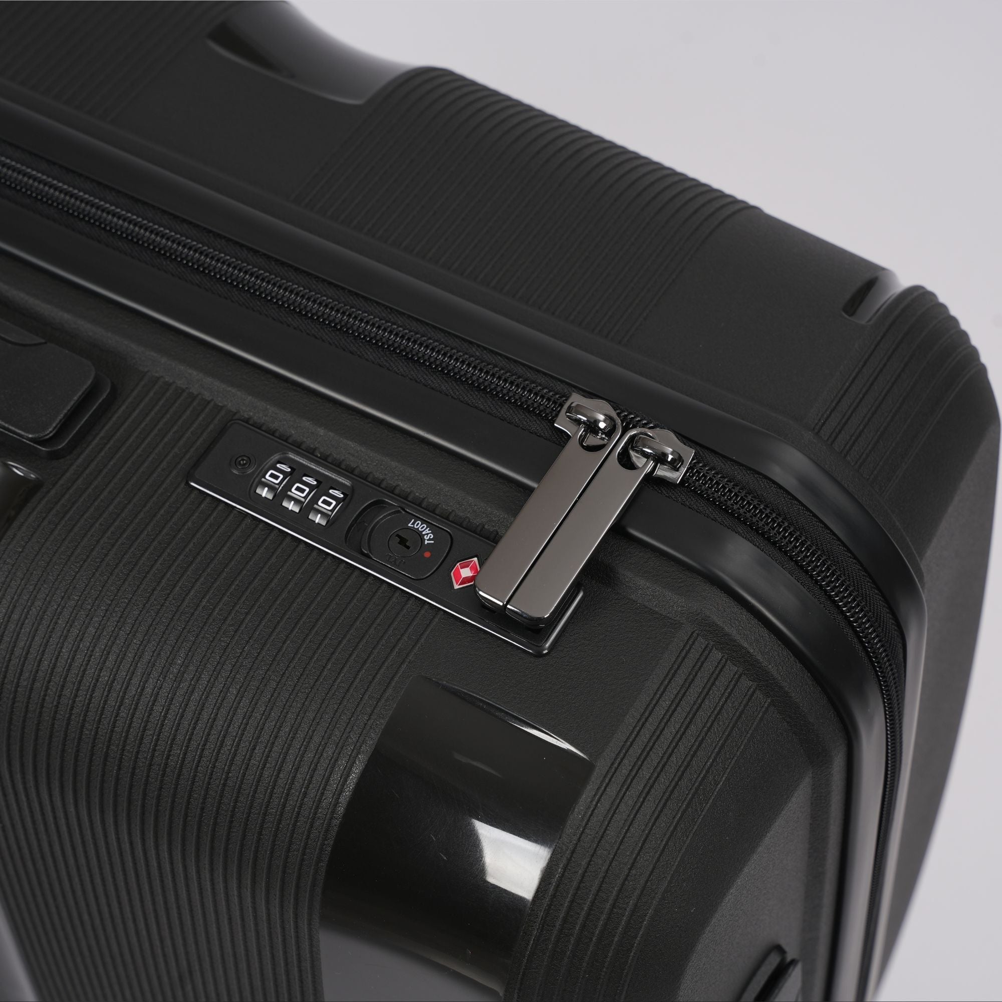 Close-up of a black suitcase with a zipper and lock mechanism on a light gray background