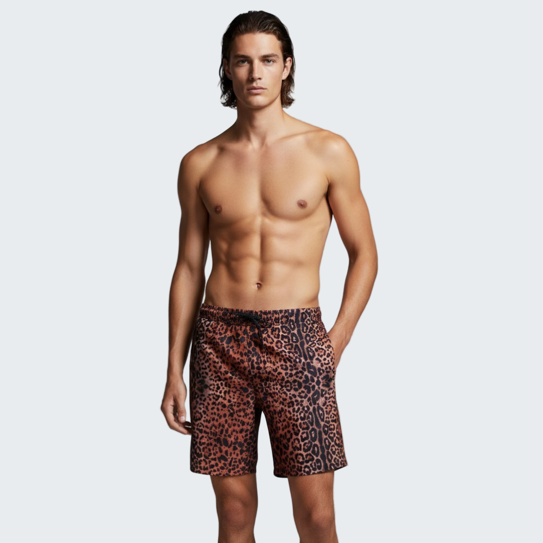Man wearing leopard print swim shorts against a gray background