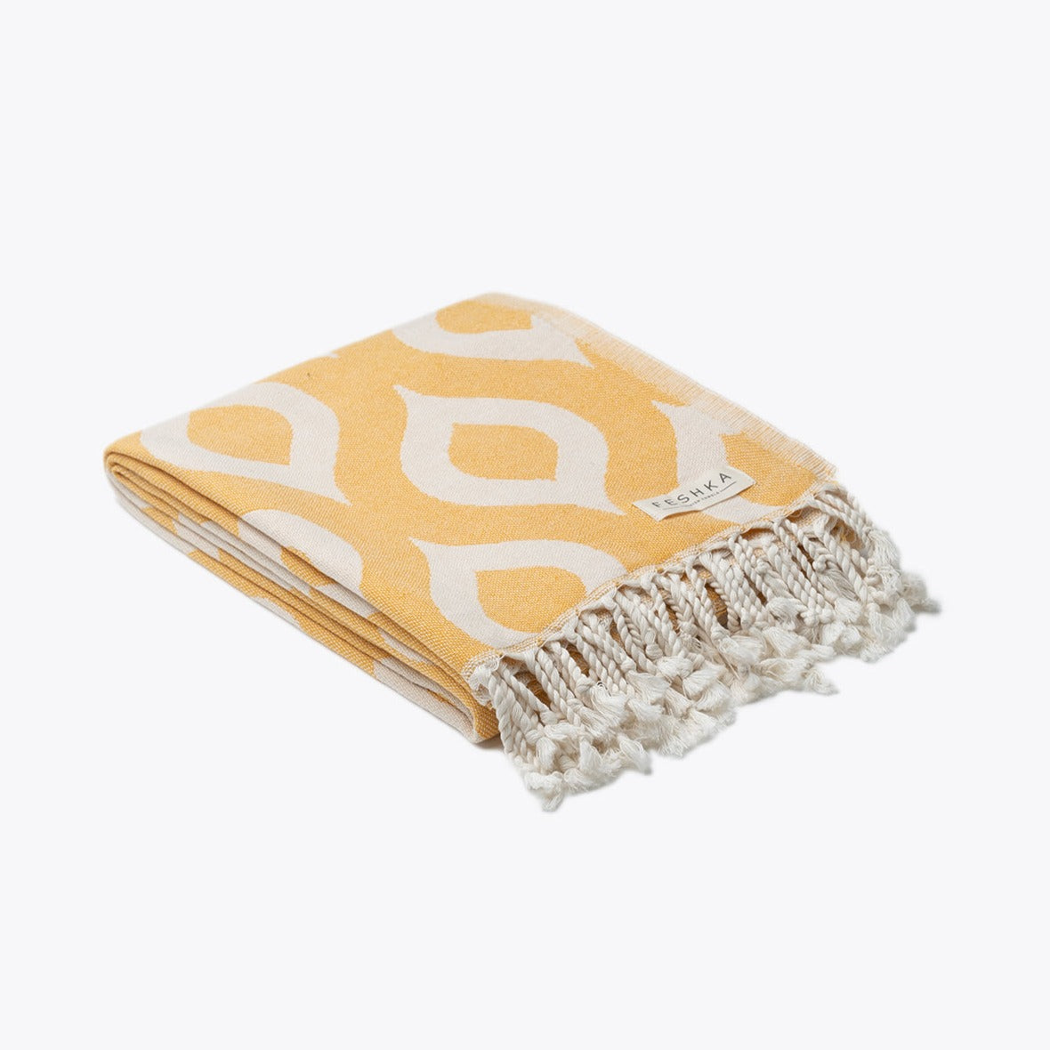 Yellow towel with white geometric pattern and fringes on a white background