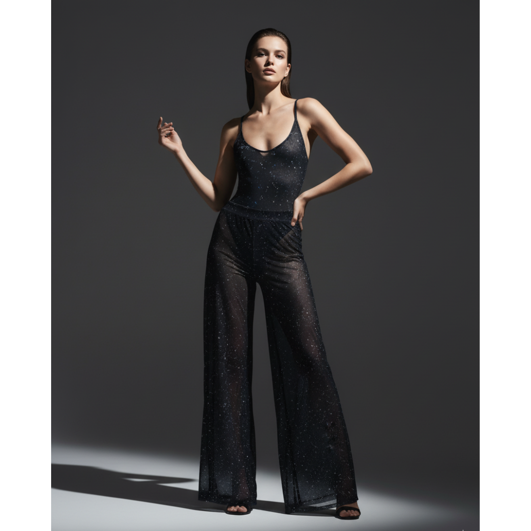 Woman wearing a black outfit with wide-leg pants against a gray background