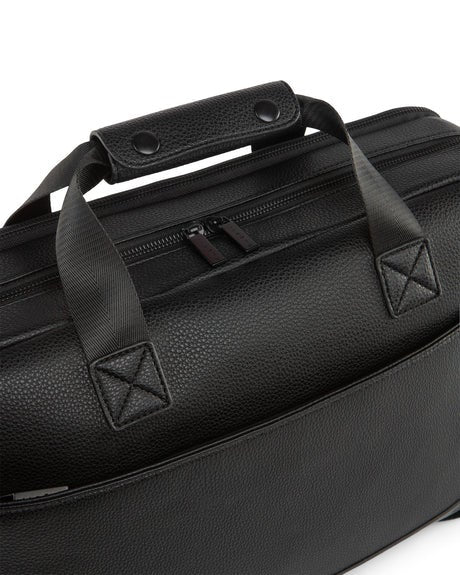 Black leather duffel bag with handles and zippers on a white background