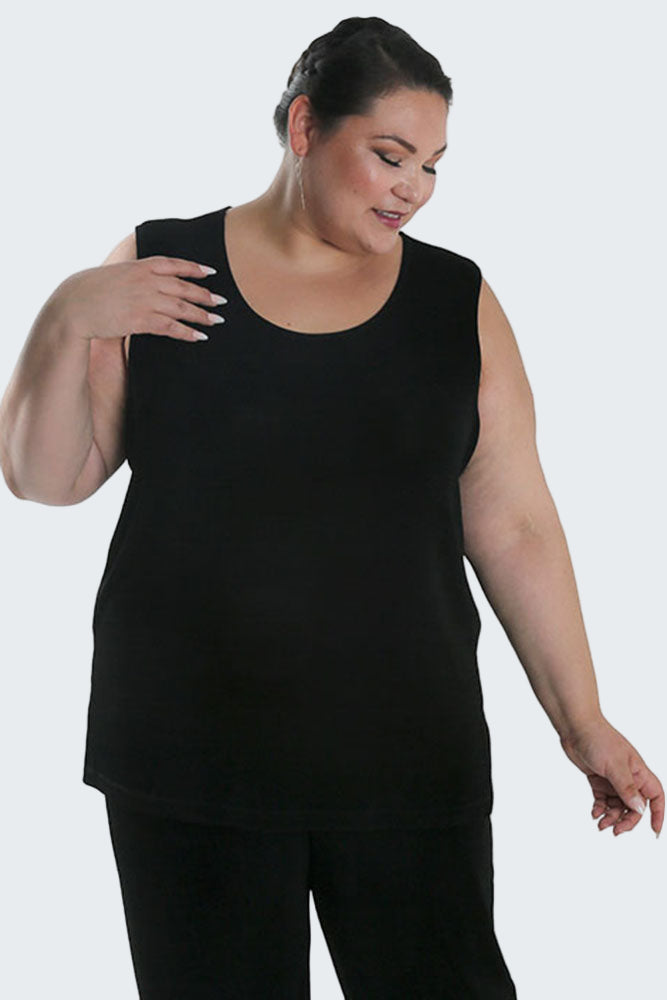 Woman wearing a black sleeveless top and pants on a white background