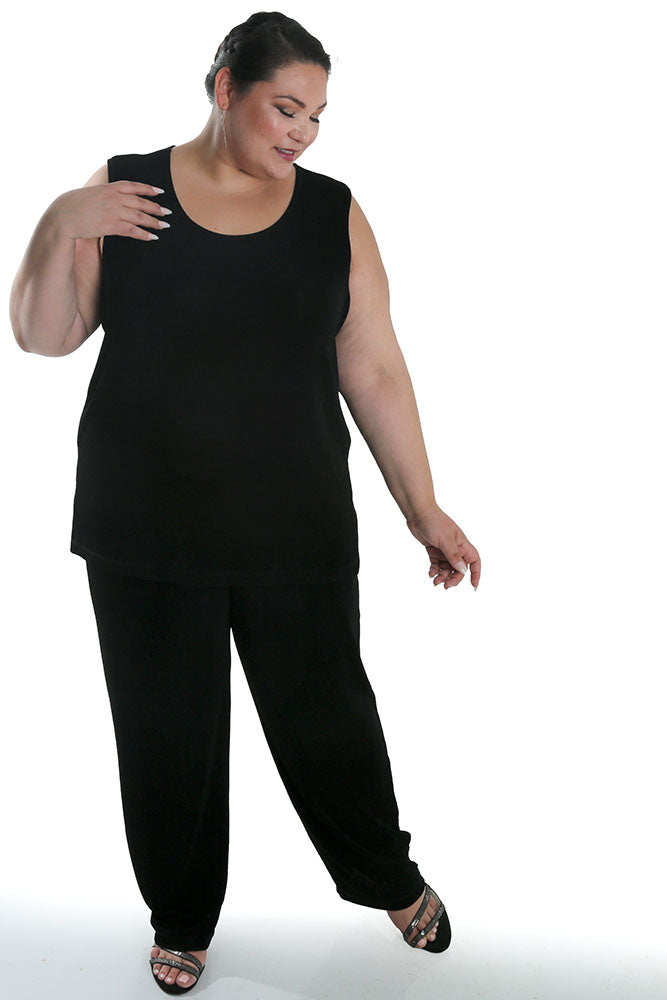 Woman wearing a black sleeveless top and pants on a white background