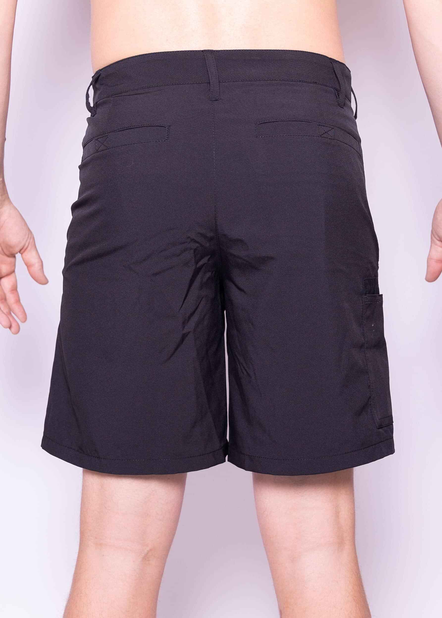 Black shorts worn by a person on a plain background