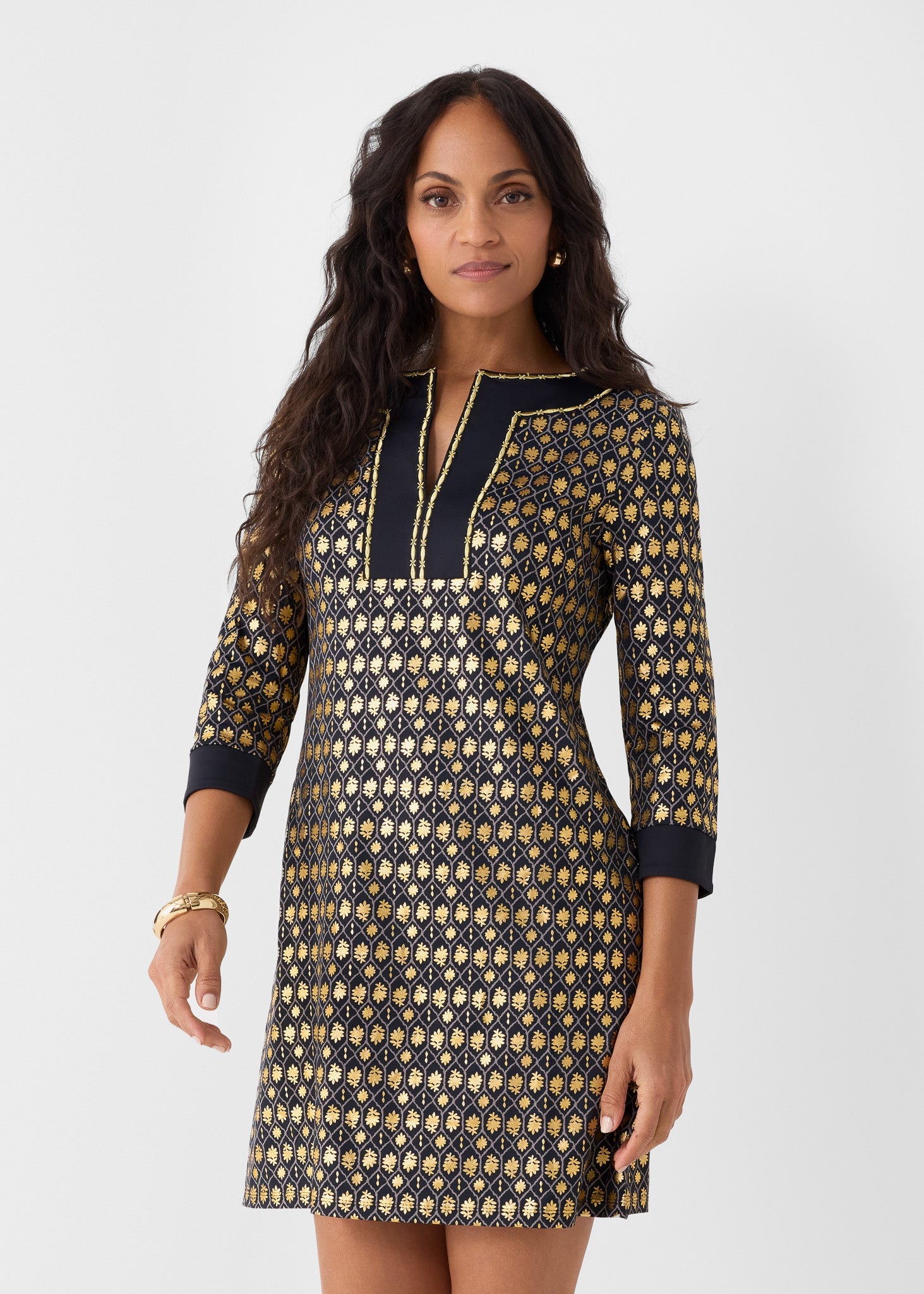 Woman wearing a patterned dress with long sleeves on a white background