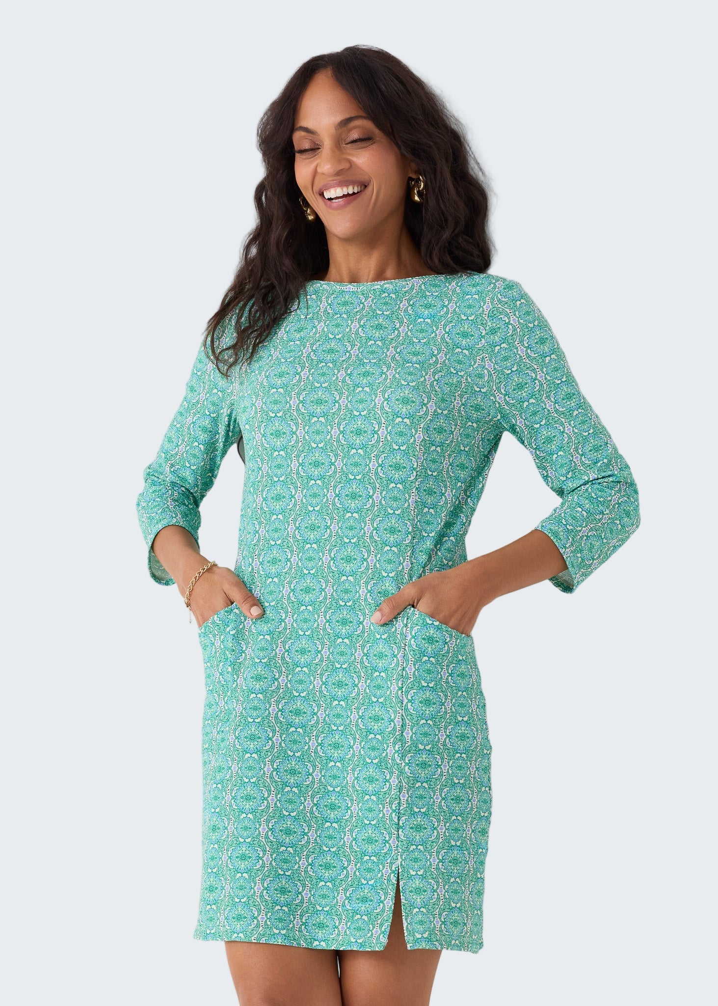 Woman wearing a green patterned dress against a white background