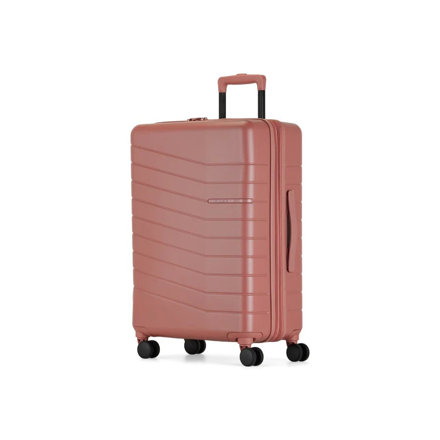 Pink suitcase with a textured surface on a white background