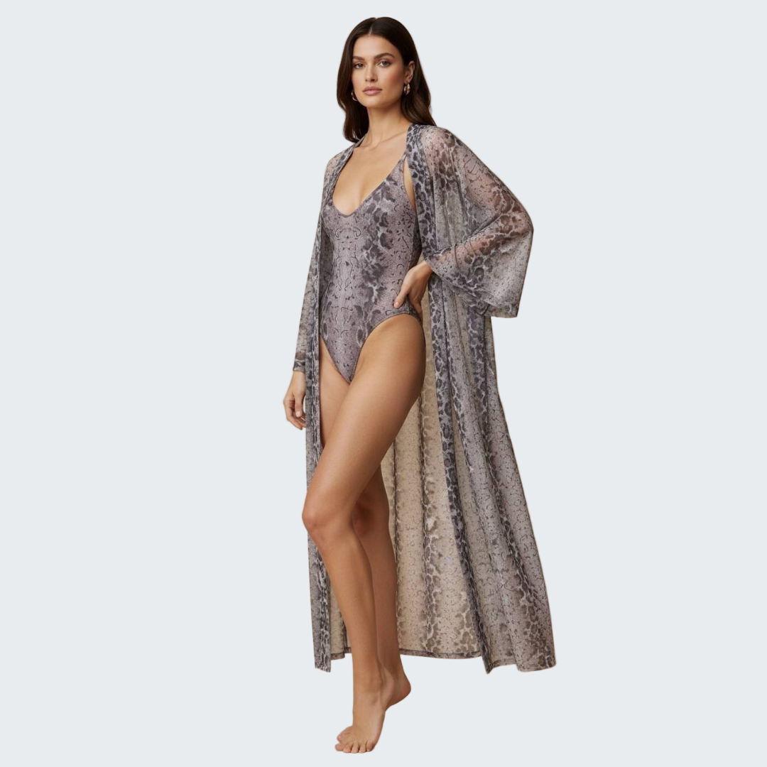 Woman wearing a patterned swimsuit and cover-up against a beige background