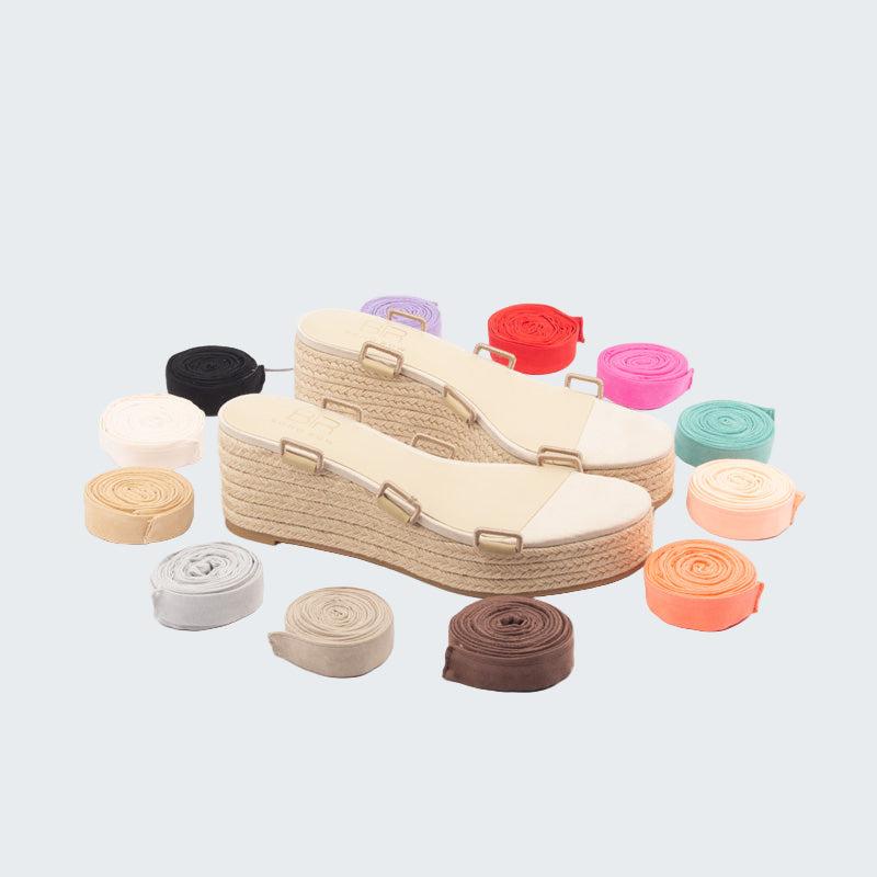 Beige wedge sandals with colorful shoe straps on a white background