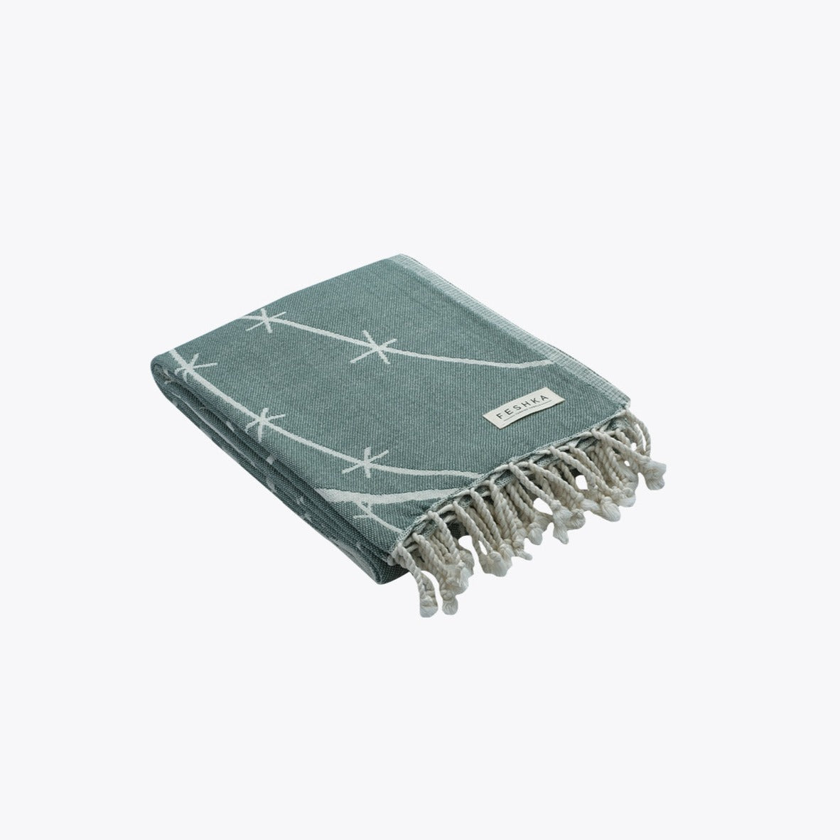 Green towel with white patterns and fringes on a white background