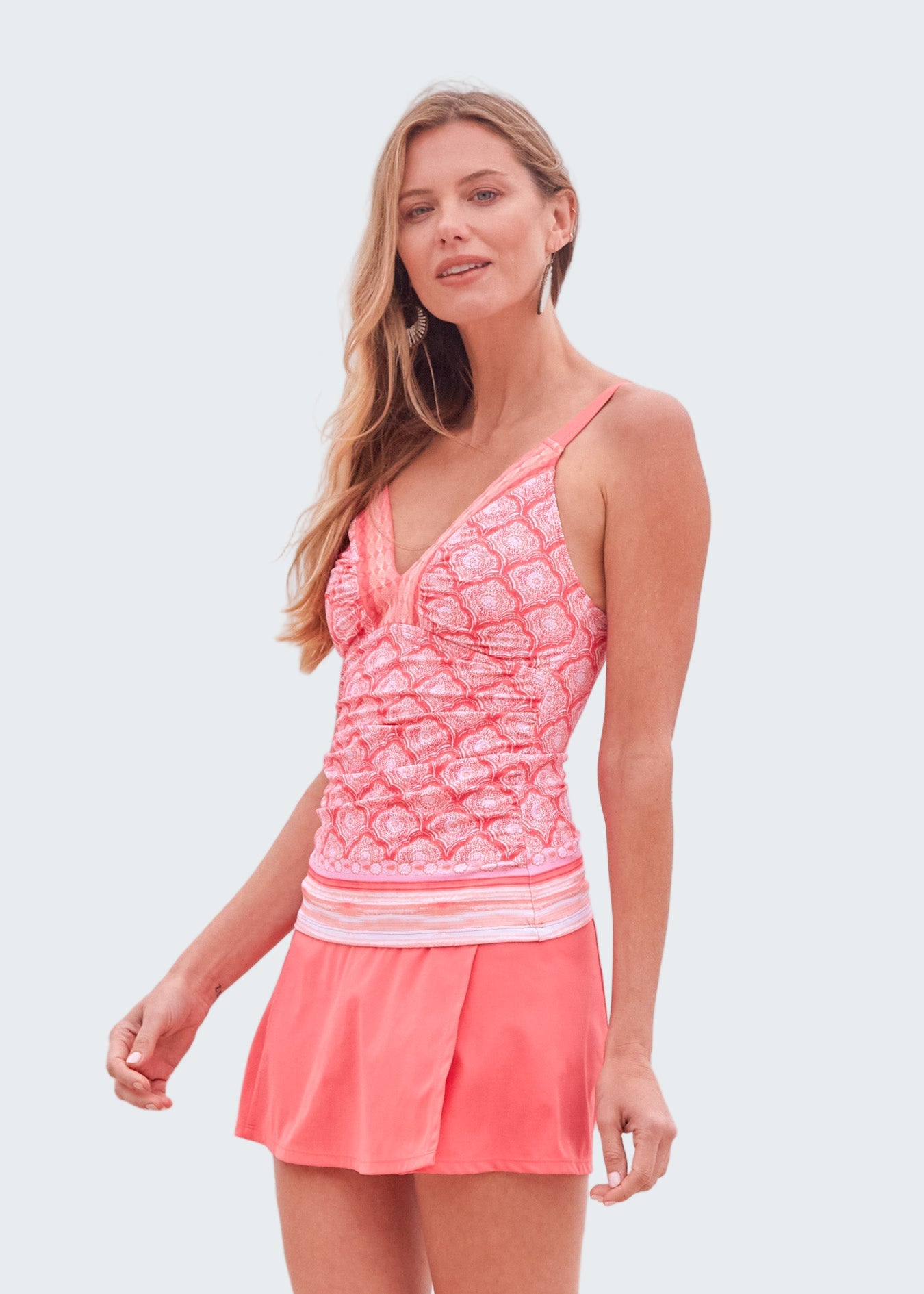 Woman wearing a pink swimsuit with ocean in the background