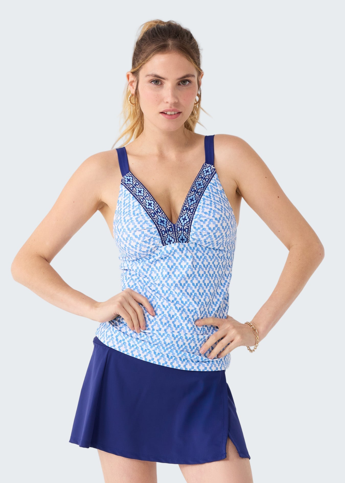 Woman wearing a blue and white patterned tank top with a matching skirt on a white background