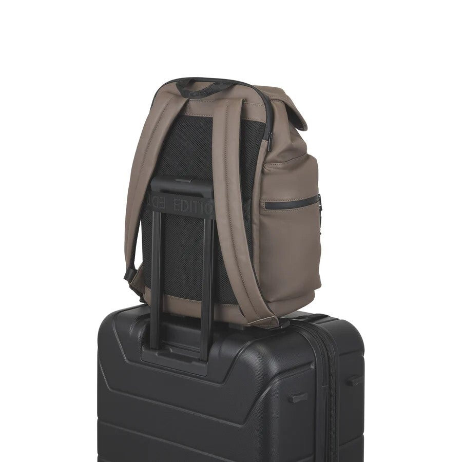 Brown backpack on top of a black suitcase with 'Travelon' branding.