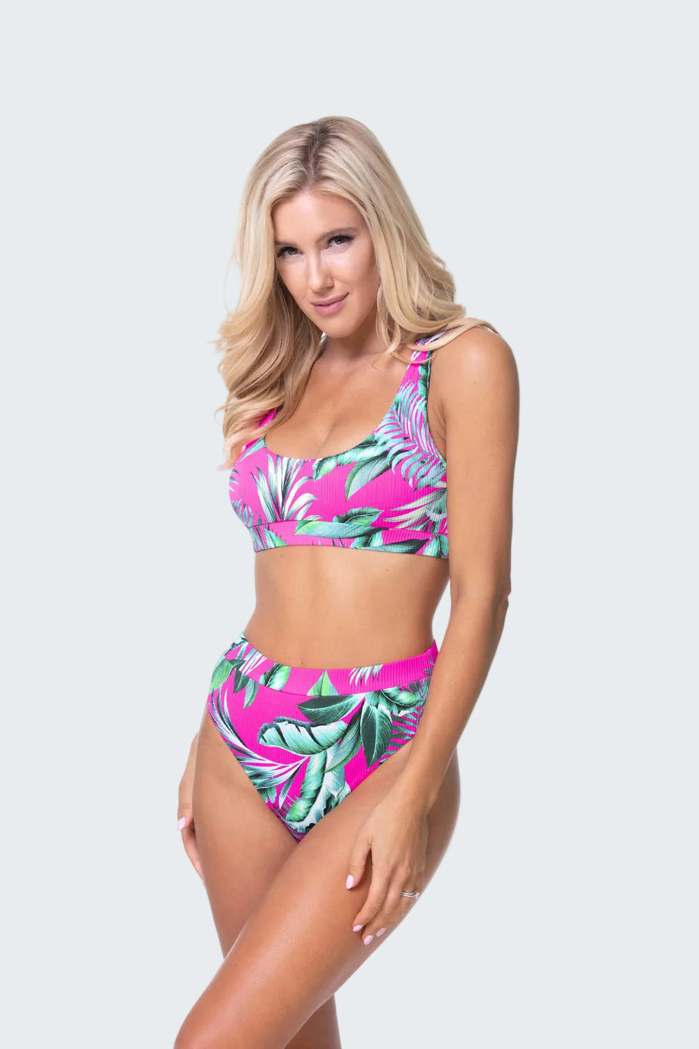 Woman wearing a tropical leaf patterned bikini set on a white background