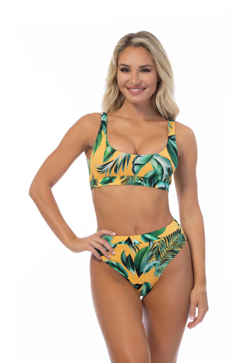 Woman wearing a tropical leaf patterned bikini set on a white background