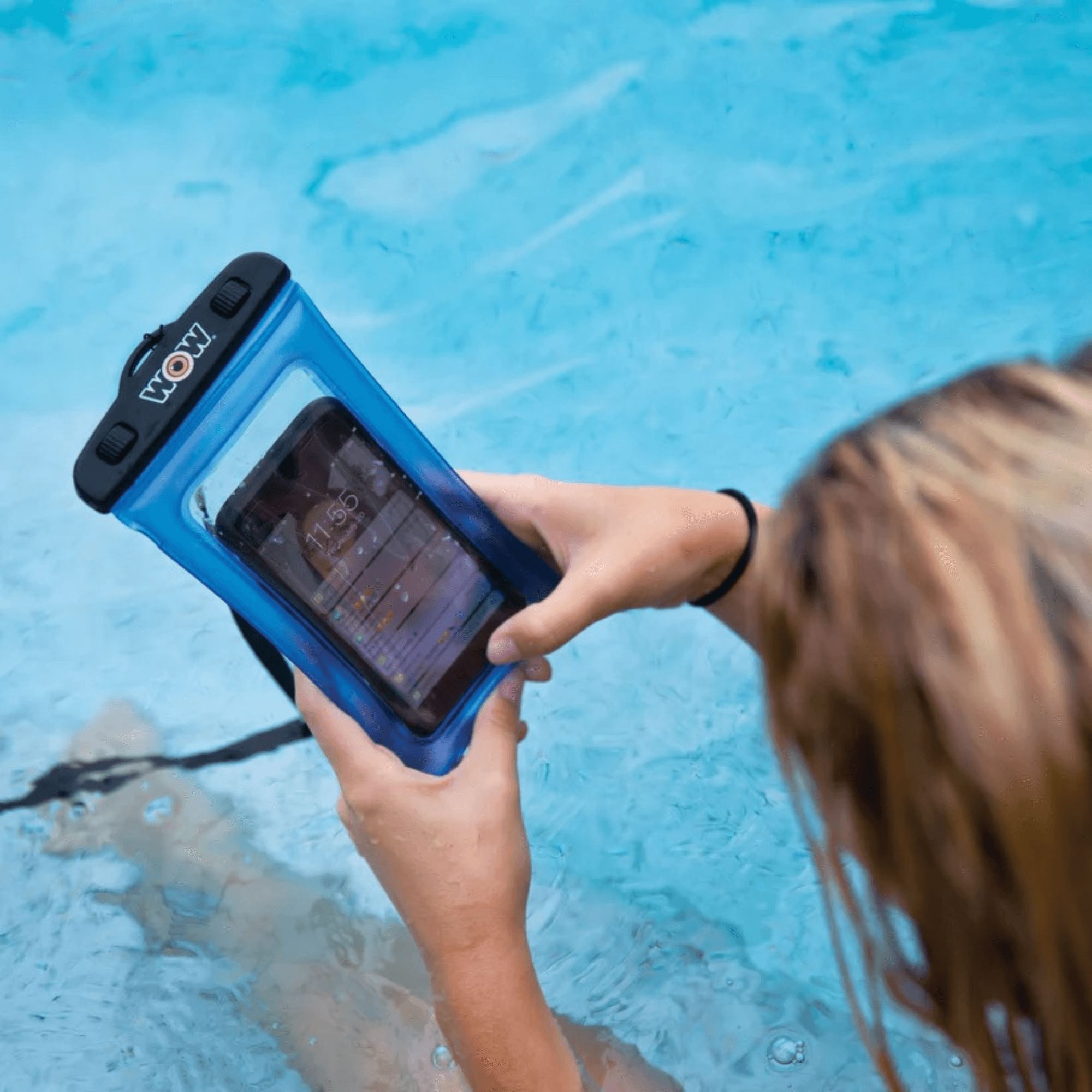 Person holding a phone in an underwater case by a pool