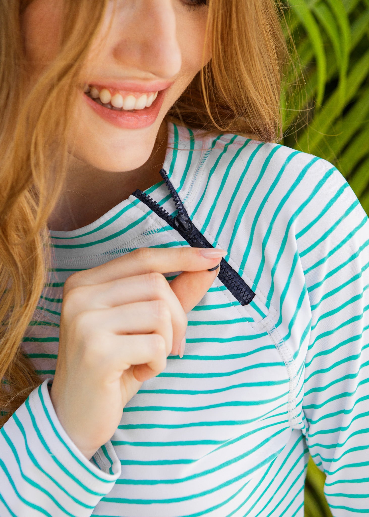 Person wearing a green and white striped shirt with a close-up of a button.