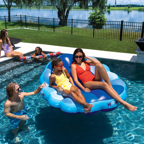 Family enjoying a pool day with a blue inflatable raft in a swimming pool.