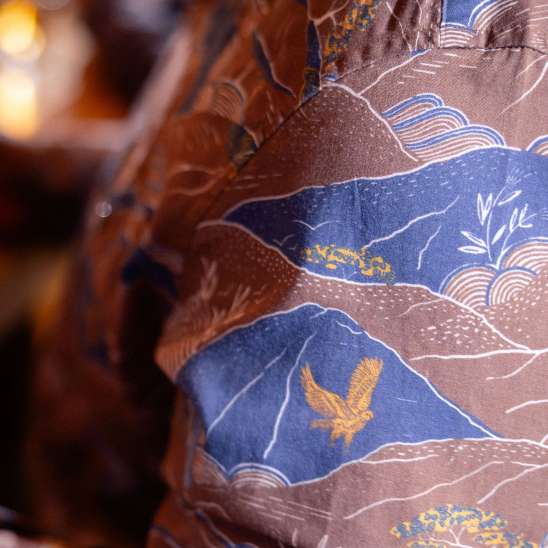 Close-up of a shirt with a detailed pattern featuring an eagle and landscape design.