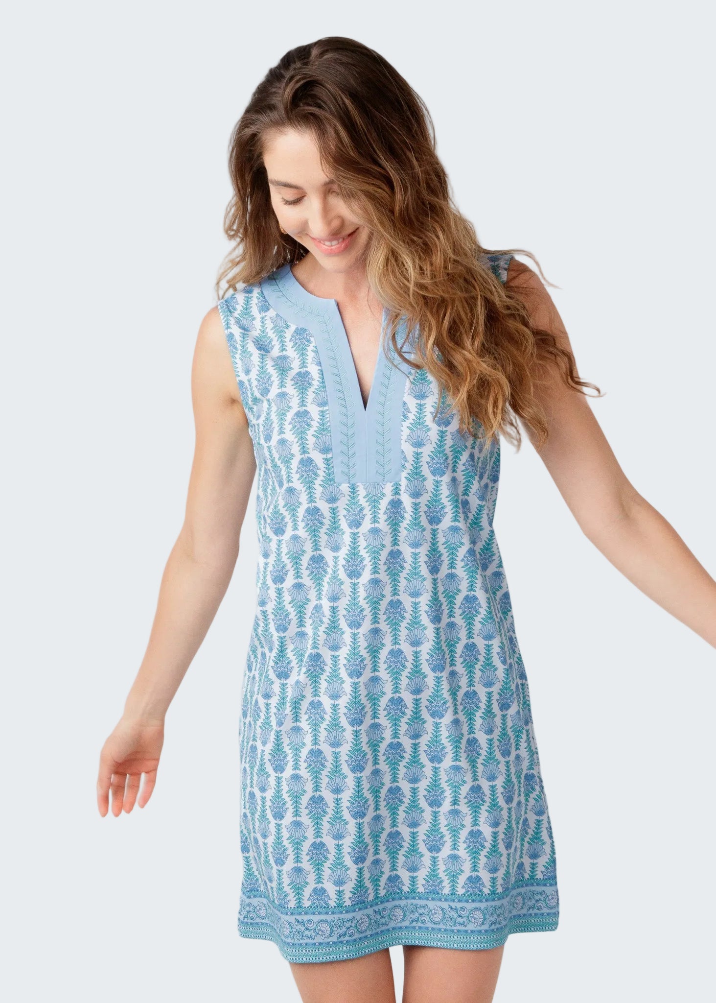 Woman wearing a blue patterned dress on a white background