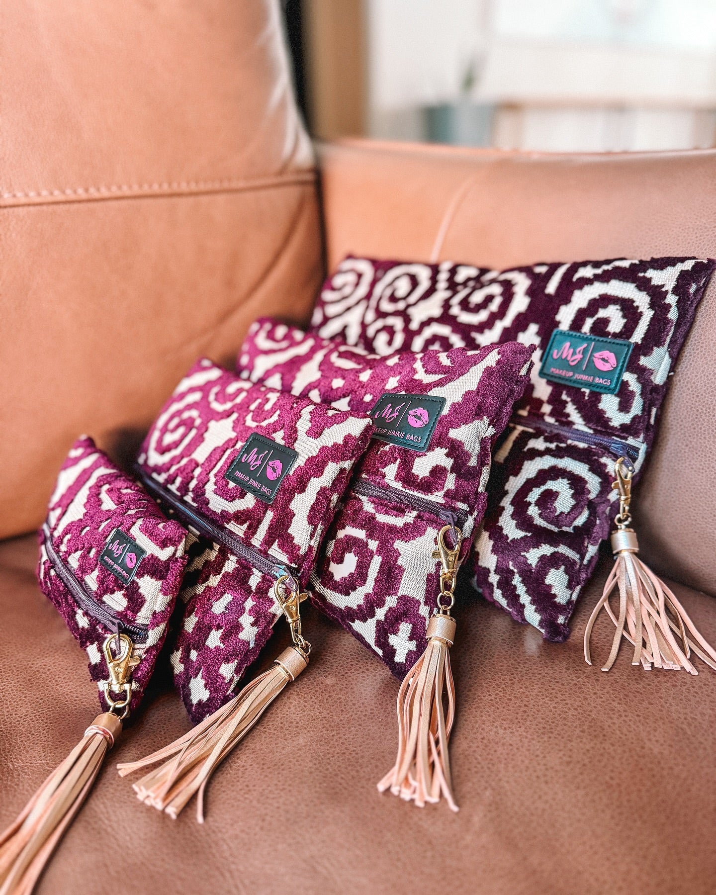 Set of patterned bags with tassels on a brown leather couch