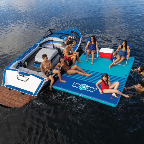 People enjoying a day on a blue and white inflatable platform with 'WOW' branding in the water.