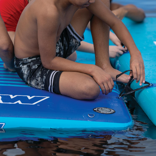 Children sitting on a blue Wavestorm paddleboard in water