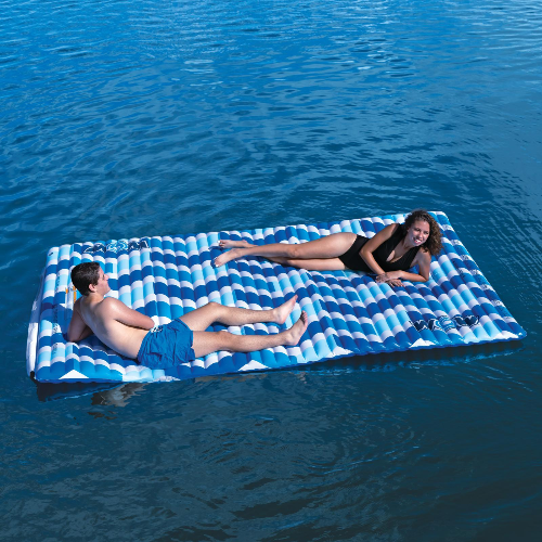 Two people lying on a blue and white striped inflatable raft in the water.