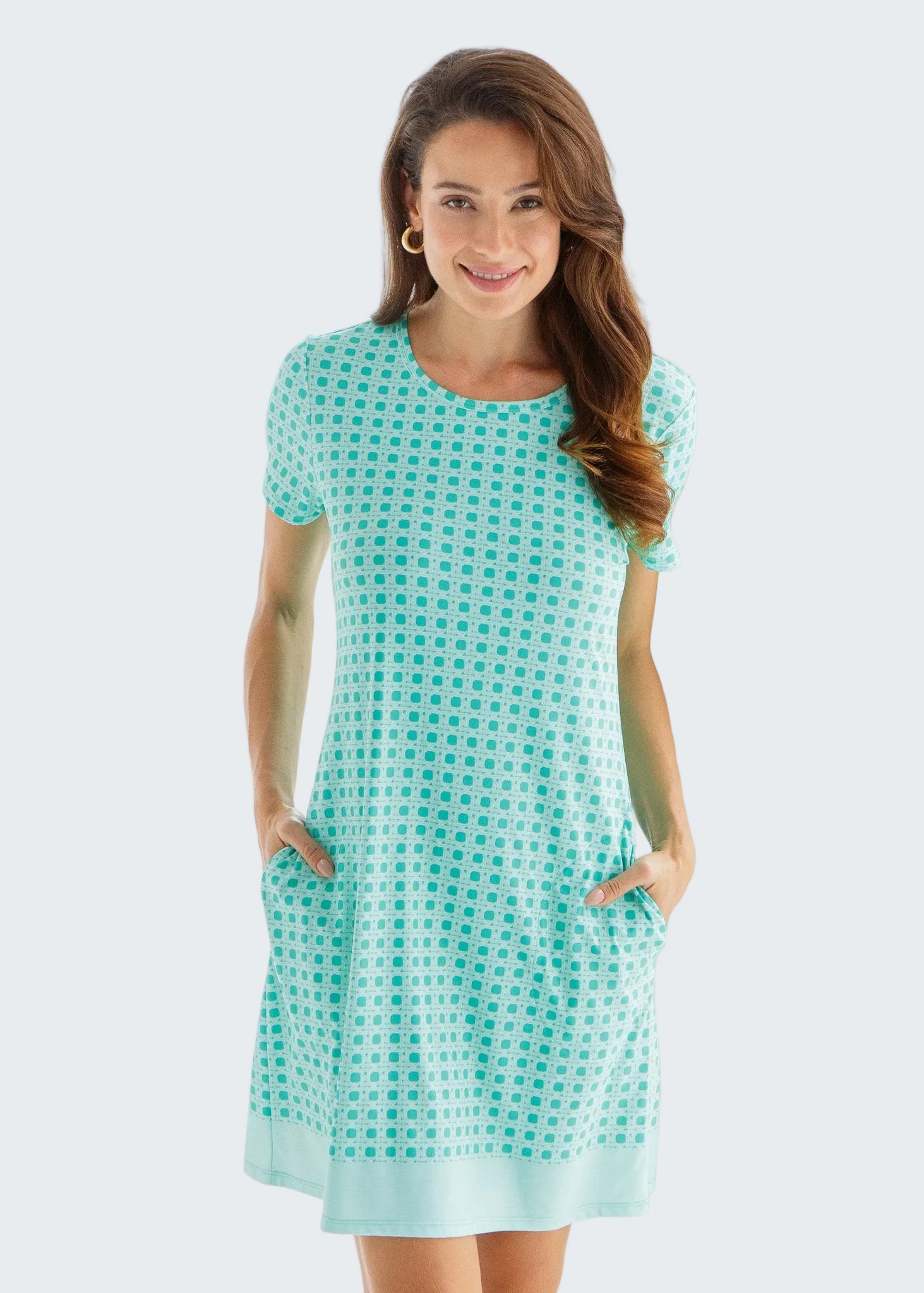 Woman wearing a turquoise checkered dress against a white background
