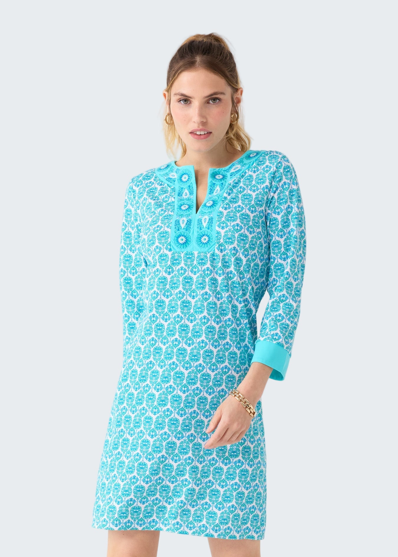 Woman wearing a blue patterned dress on a white background