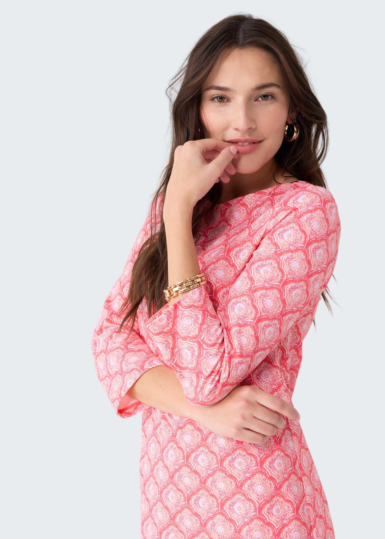 Woman wearing a pink patterned dress on a white background