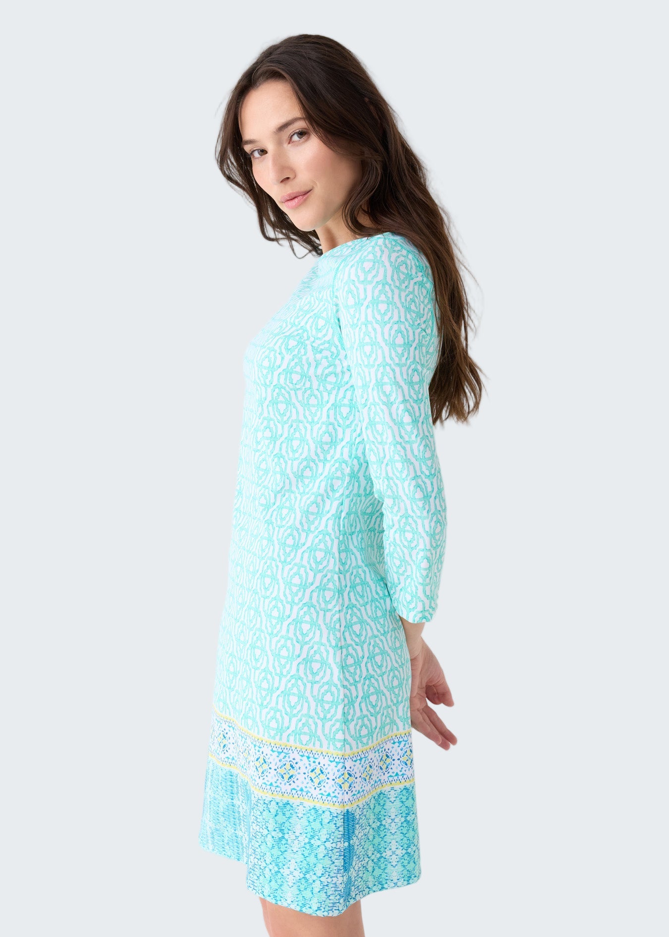 Woman wearing a light blue dress with a pattern on a white background