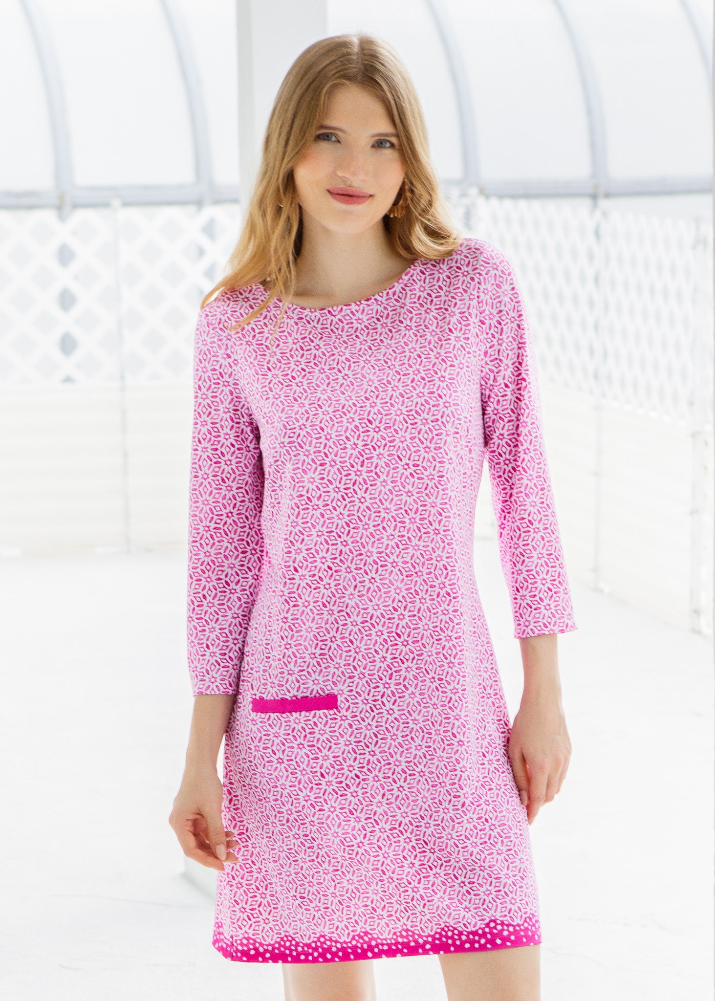 Woman wearing a pink patterned dress against a white background