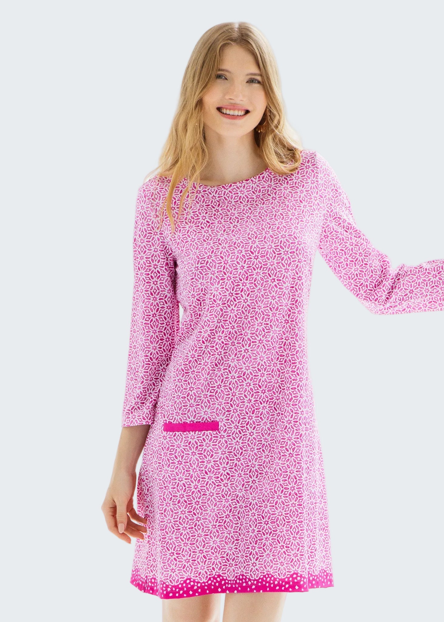 Woman wearing a pink patterned dress against a white background