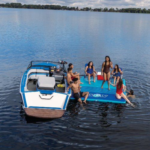 Group of people on a floating dock attached to a boat on a lake