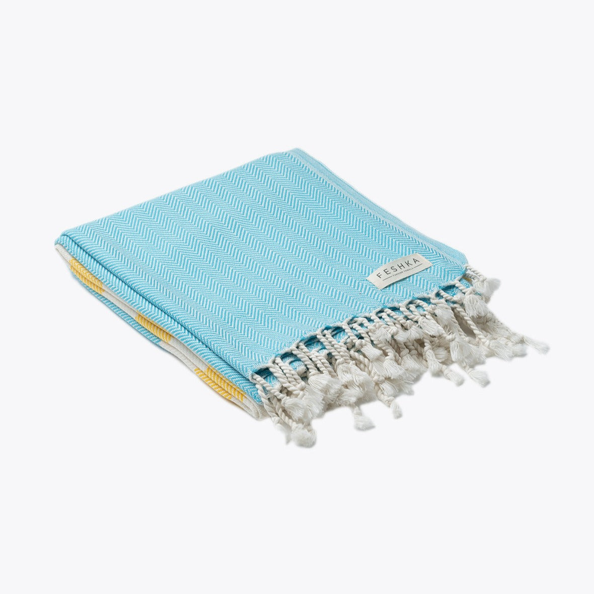 Light blue towel with white tassels on a white background