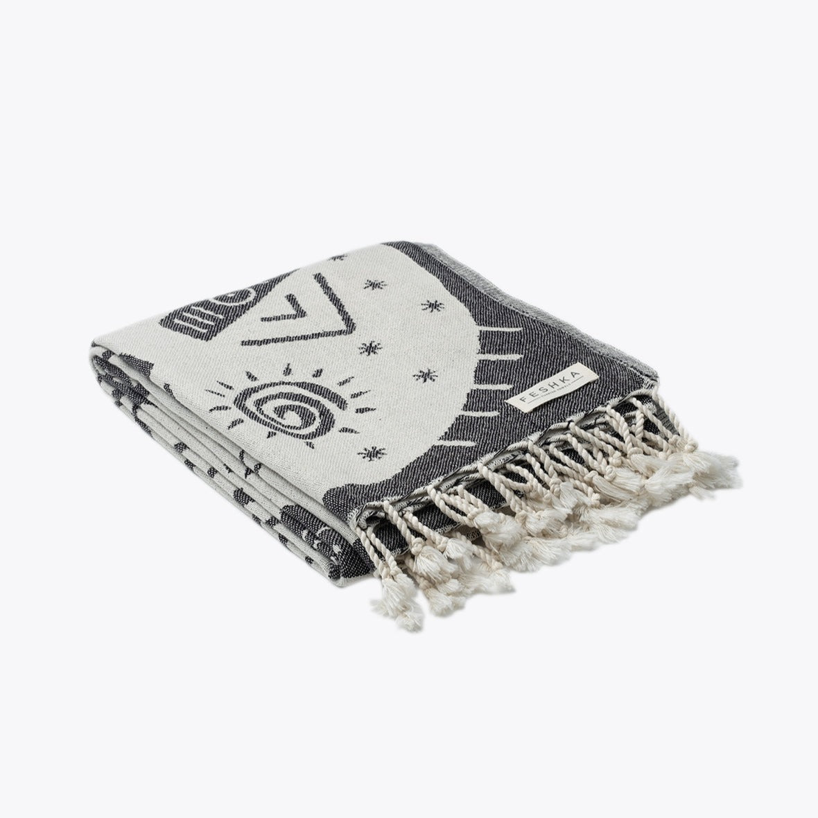 Black and white patterned towel with fringes on a white background